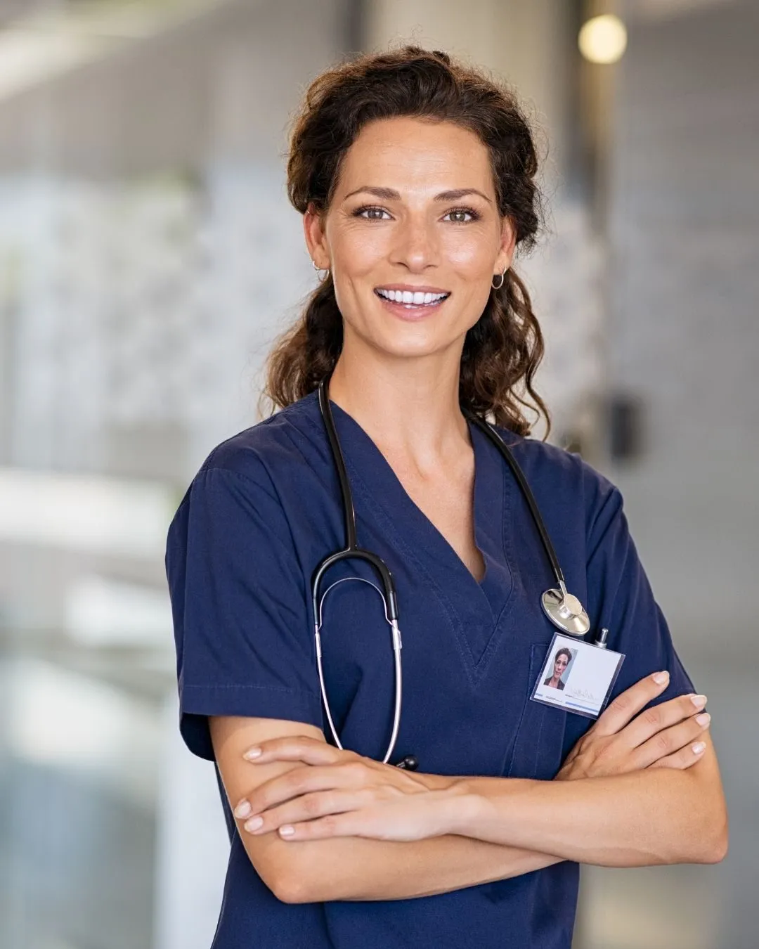 Smiling nurse in navy scrubs with a stethoscope around her neck