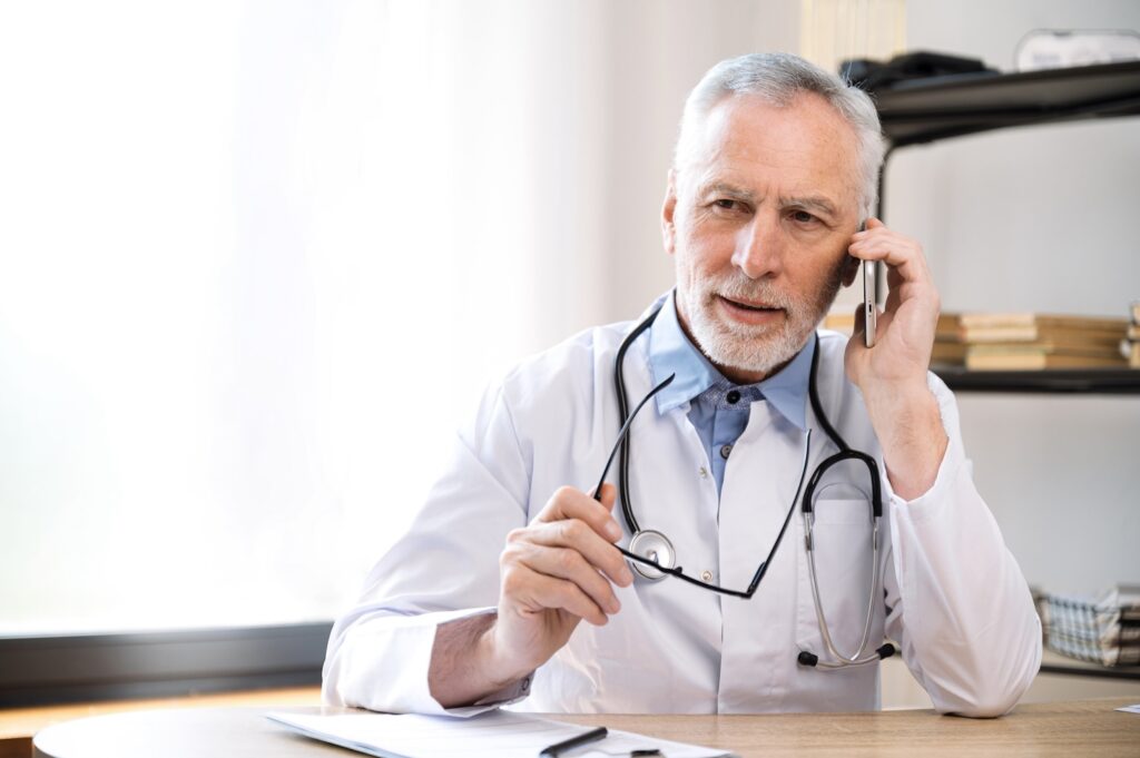 man doctor talking with patient by smartphone