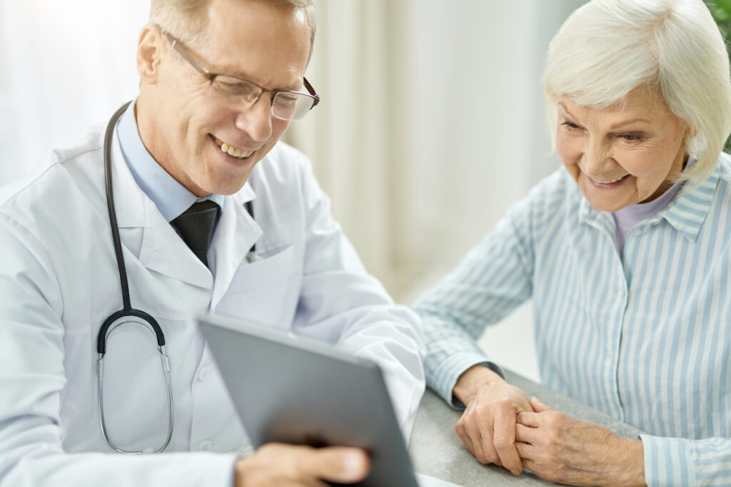 Doctor with happy elderly patient, improving satisfaction