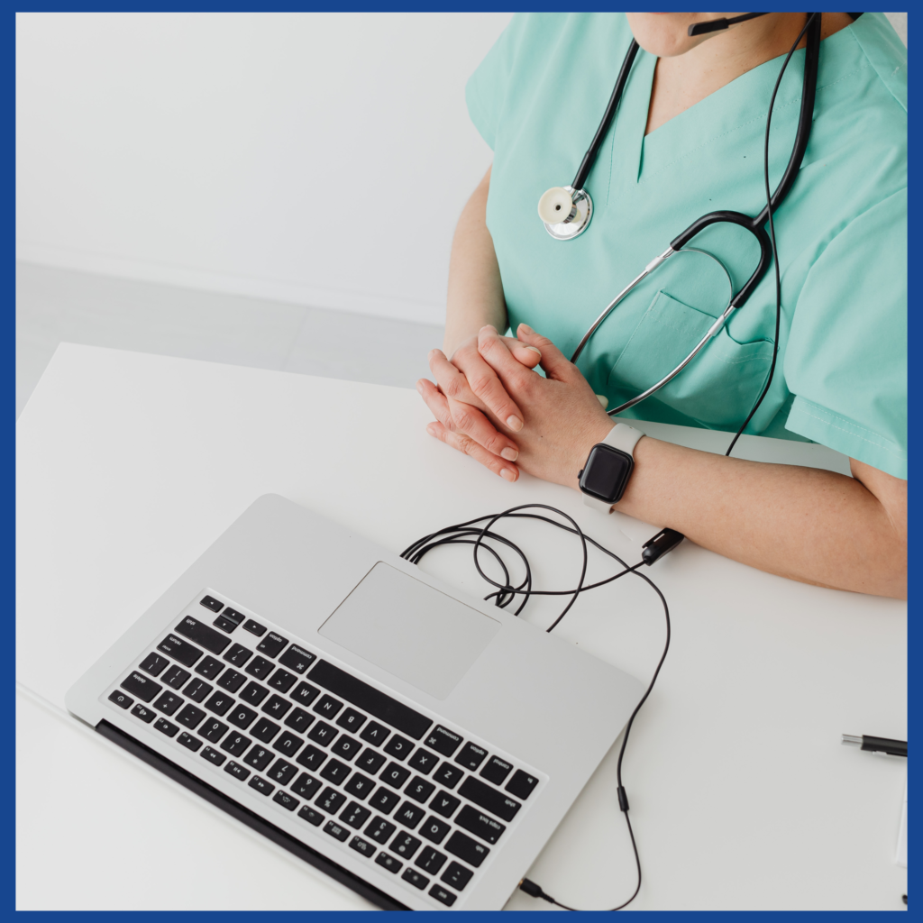 Nurse updating records on laptop